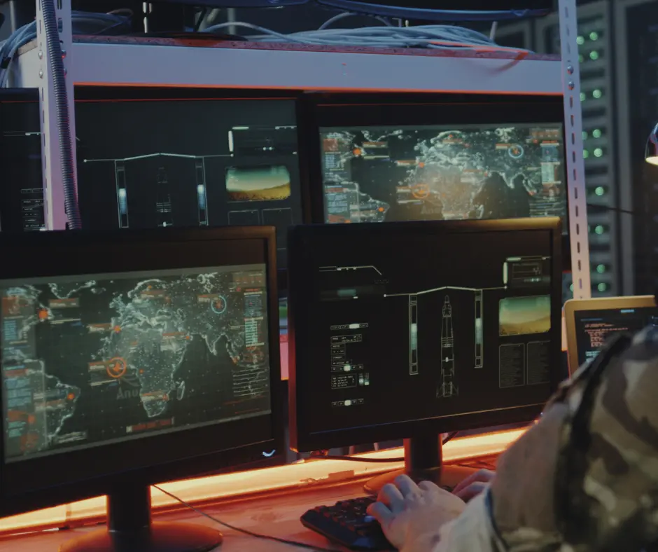 OJN specializes in intelligence, depicted with a view from behind a man in a military uniform sitting at a desk with computer screens displaying global tracking maps